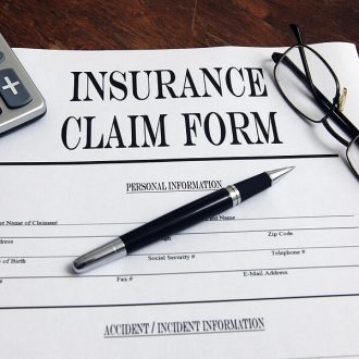 blank insurance claim form with pen and glasses